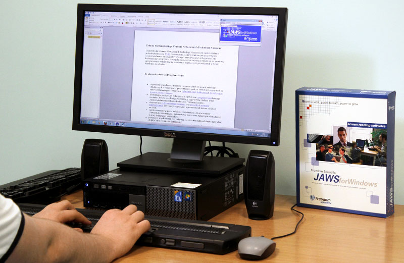 A desk running JAWS for Windows screen reading software, with the software's box beside the monitor.